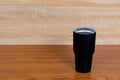 Black colour stainless steel tumbler or cold storage cup on wood Royalty Free Stock Photo