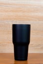 Black colour stainless steel tumbler or cold storage cup on wood Royalty Free Stock Photo