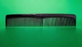 Black comb on a green background for hair care Royalty Free Stock Photo