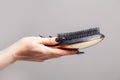 Black comb and hair in female hand, hair loss and hair care concept Royalty Free Stock Photo