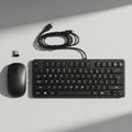 Black computer keyboard and mouse set displayed on a light gray surface Royalty Free Stock Photo