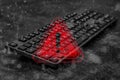 Black computer keyboard with a red warning triangle and exclamation mark overlay with digital binary code data. Concept Royalty Free Stock Photo