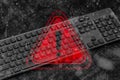 Black computer keyboard with a red warning triangle and exclamation mark overlay with digital binary code data. Concept Royalty Free Stock Photo