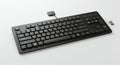 Black computer keyboard with a USB connector on a white surface. The keyboard Royalty Free Stock Photo