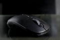 Black computer mouse on black background