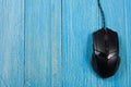 Black computer mouse on a blue wooden background with copy space for your text. Top view Royalty Free Stock Photo