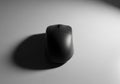 A black computer mouse is centered on a smooth, light gray Royalty Free Stock Photo