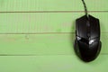 Black computer mouse on a green wooden background with copy space for your text. Top view Royalty Free Stock Photo