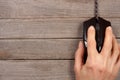 Black computer mouse with a hand on old wooden background with copy space for your text. Top view Royalty Free Stock Photo