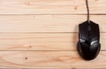 Black computer mouse on a light wooden background with copy space for your text. Top view Royalty Free Stock Photo