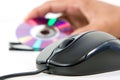 Black computer mouse and optical data disc in back Royalty Free Stock Photo
