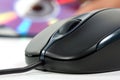 Black computer mouse and optical data disc in back Royalty Free Stock Photo