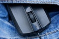 Black computer mouse with a wire in the pocket of blue trousers Royalty Free Stock Photo