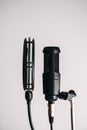 Black condenser microphone on stand with pop filter isolated on gray background Royalty Free Stock Photo