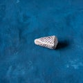 Black Cone on a blue background. Conus Marmoreus. Shell With White Triangle. Royalty Free Stock Photo