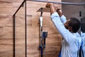 Black confident Professional handyman working in shower bath indoors, side view portrait Royalty Free Stock Photo