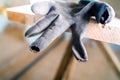 Black construction glove with rubbed fingers close-up. Holeful work gloves at a construction site on wooden scaffolding. Poor Royalty Free Stock Photo