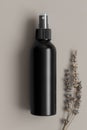 Black cosmetic spray bottle mockup with a lavender on the beige background Royalty Free Stock Photo