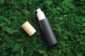 Black cosmetic spray bottle mockup on moss background. Flat lay, top view. Herbal cosmetics branding, natural beauty product Royalty Free Stock Photo