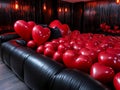 A black couch with lots of red heart shaped balloons on it Royalty Free Stock Photo