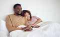 Black couple, bedroom tv watching and bed rest in the morning together with love and care. Happiness, home and smile of Royalty Free Stock Photo