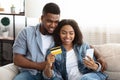 Black couple buying online, using smartphone and credit card at home