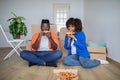 Black Couple Celebrating Moving Home, Sitting On Floor And Eating Takeaway Pizza Royalty Free Stock Photo