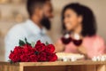 Black couple having dinner, focus on red roses Royalty Free Stock Photo