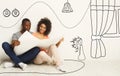 Black couple holding house plan and dreaming about new interior design, collage with drawings on white wall Royalty Free Stock Photo