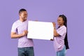 Black couple holding and looking at blank white advertising placard Royalty Free Stock Photo