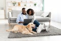 Black couple at home using laptop relaxing with dog Royalty Free Stock Photo