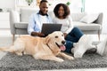Black couple at home using pc laptop relaxing with dog Royalty Free Stock Photo