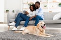 Black couple at home using tablet relaxing with dog Royalty Free Stock Photo