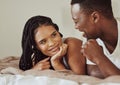 Black couple, love and bedroom conversation while happy together on a bed in a house, apartment or hotel. Face of young Royalty Free Stock Photo