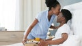 Black couple, love bond or breakfast in bed with kiss on forehead for happy, smile or trust in house, home or hotel Royalty Free Stock Photo