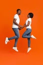 Black couple in love holding hands and jumping up Royalty Free Stock Photo