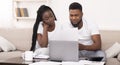 Black couple managing family budget at home together, reading financial documents Royalty Free Stock Photo