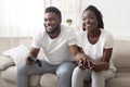 Black couple playing video games at home, competing with each other Royalty Free Stock Photo