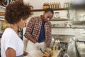 Black couple prepare food behind counter at a sandwich bar Royalty Free Stock Photo