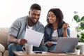 Black couple reading financial documentation at home while planning family budget Royalty Free Stock Photo