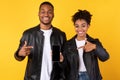 Black Couple Showing Smartphone With Blank Screen Over Yellow Background Royalty Free Stock Photo