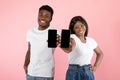 Black couple showing two blank empty smartphones screen for mockup Royalty Free Stock Photo