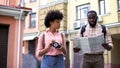 Black couple of tourists with map and photo camera, choosing direction, travel Royalty Free Stock Photo