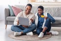 Black couple using laptop and debit credit card at home Royalty Free Stock Photo