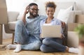 Black Couple Using Laptop Sitting On Floor In New Apartment Royalty Free Stock Photo