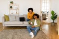 Black Couple Using Phone Browsing Internet, Sitting Near Laptop Indoor Royalty Free Stock Photo