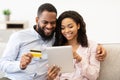 Black couple using tablet and credit card at home Royalty Free Stock Photo