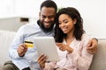 Black couple using tablet and debit credit card at home Royalty Free Stock Photo