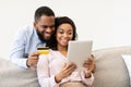 Black couple using tablet and debit credit card at home Royalty Free Stock Photo