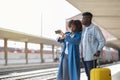 Black couple waiting for train arrival on platform at railway station Royalty Free Stock Photo